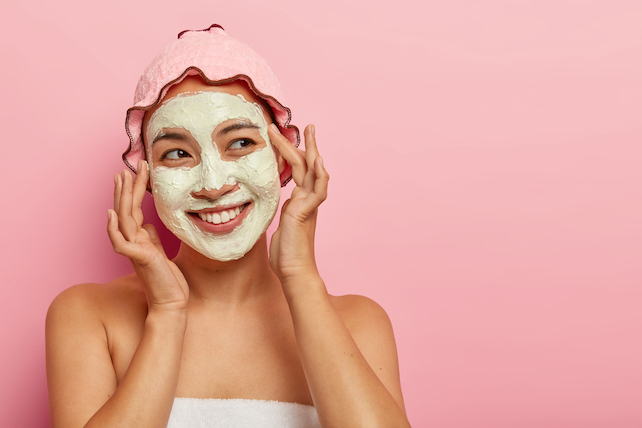 Selbstfürsorge - glückliche Frau mit Gesichtsmaske