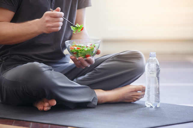 Brainfood gegen Vergesslichkeit - Person im Schneidersitz isst Salat