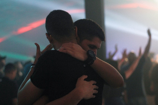 wahre Freunde - zwei junge Männer umarmen sich auf einer Party
