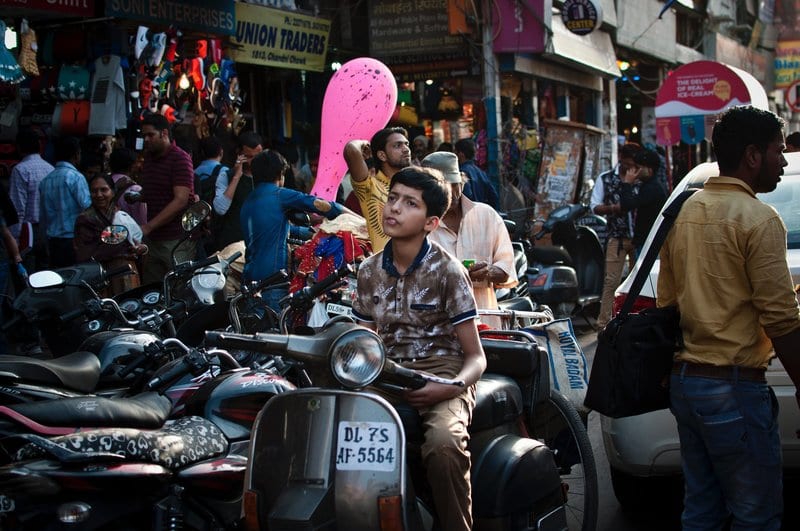Boy sitting on a motorcycle on a busy road